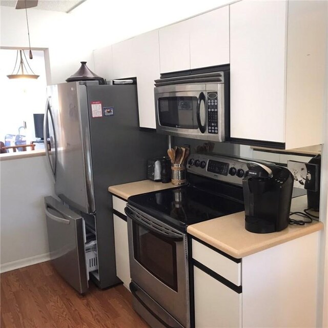 179 Grove Isle Cir Unit 179, Vero Beach, FL 32962 - kitchen with appliances with stainless steel finishes, white cabinets, light countertops, and wood finished floors