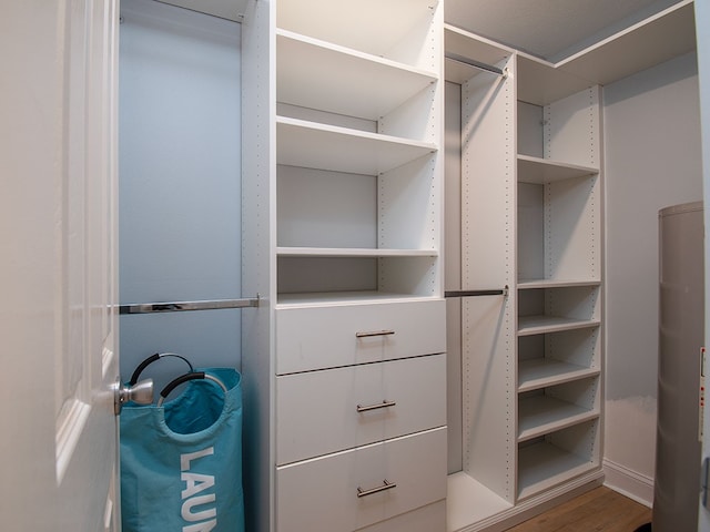 walk in closet with wood finished floors