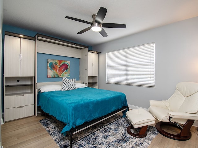 bedroom featuring light wood-style flooring, baseboards, and a ceiling fan