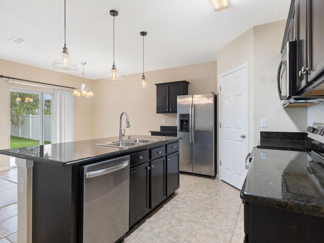 kitchen featuring a center island with sink, sink, stainless steel appliances, and hanging light fixtures