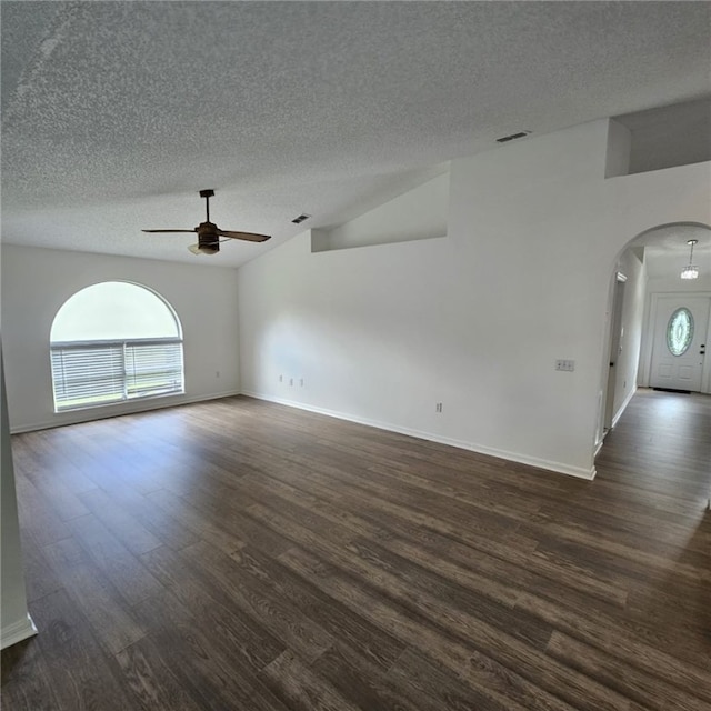 empty room featuring a textured ceiling, ceiling fan, lofted ceiling, and dark wood-type flooring