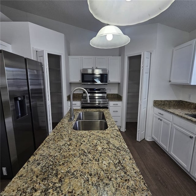 kitchen with light stone countertops, white cabinetry, sink, and appliances with stainless steel finishes