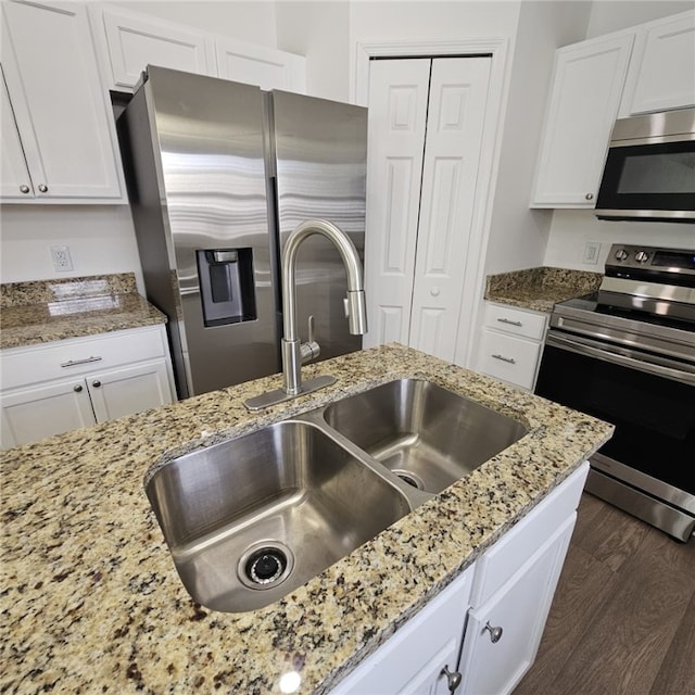 kitchen featuring appliances with stainless steel finishes, dark hardwood / wood-style flooring, white cabinetry, and sink