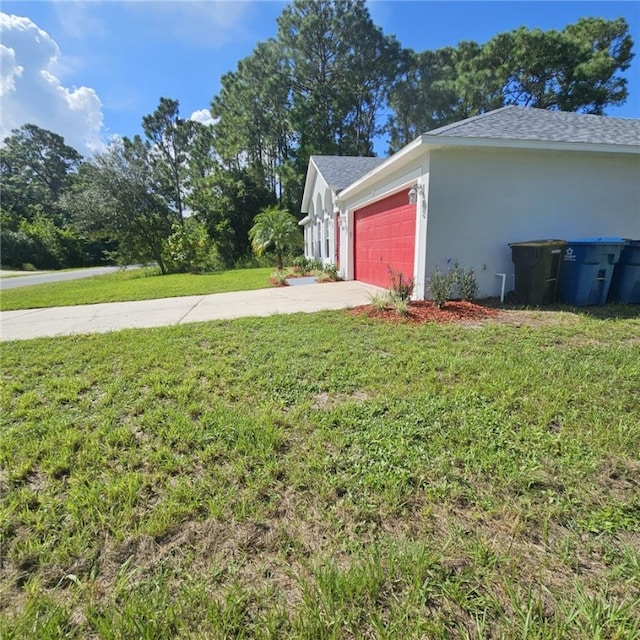 view of side of property with a garage and a yard