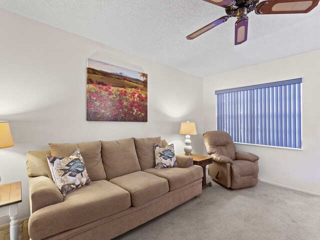 carpeted living room with ceiling fan and a textured ceiling