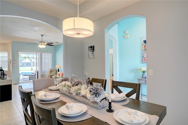 tiled dining area featuring a textured ceiling and ceiling fan