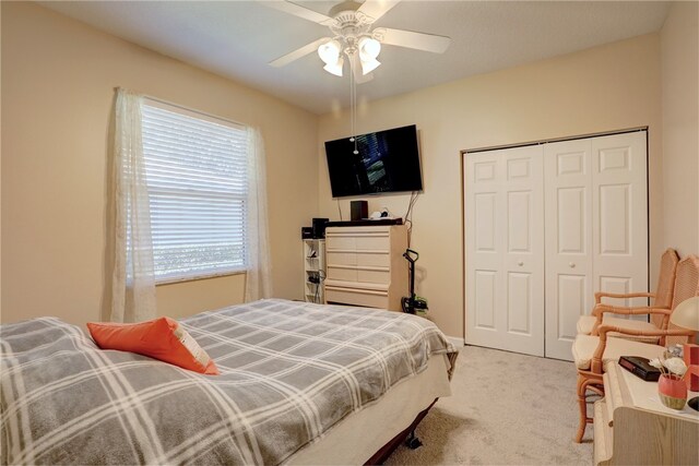 carpeted bedroom featuring ceiling fan and a closet