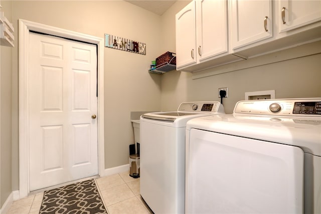 washroom with washing machine and dryer, cabinets, and light tile patterned flooring