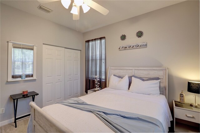 bedroom featuring light carpet, multiple windows, ceiling fan, and a closet