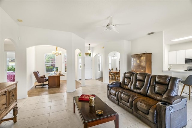 living room with light tile patterned flooring and ceiling fan with notable chandelier