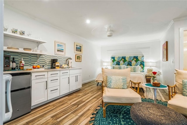 living area featuring light wood-type flooring, ceiling fan, ornamental molding, and sink