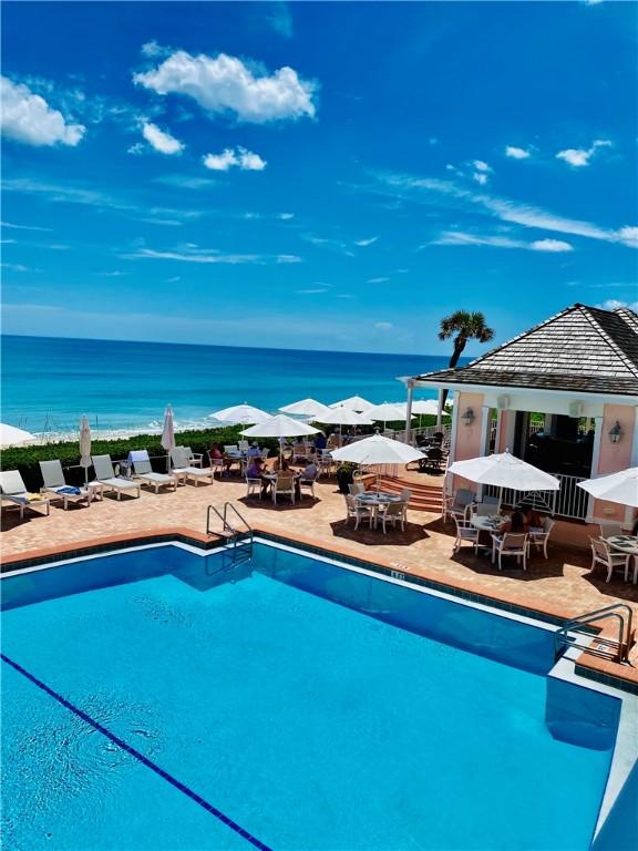 view of swimming pool with a patio area and a water view