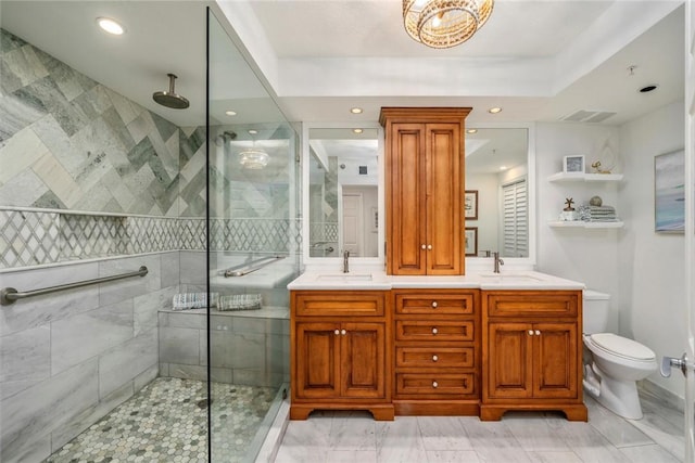 bathroom with toilet, vanity, and tiled shower