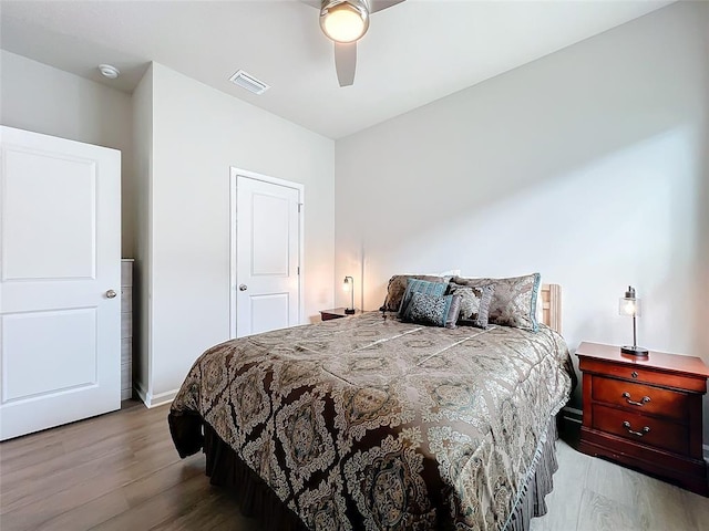 bedroom with visible vents, ceiling fan, baseboards, and wood finished floors