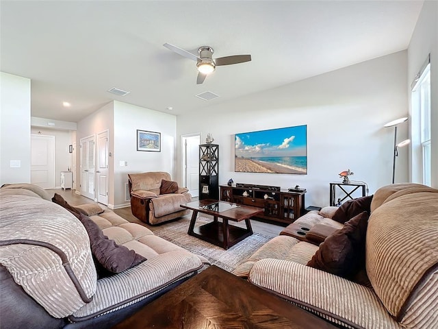 living area featuring baseboards, visible vents, and a ceiling fan