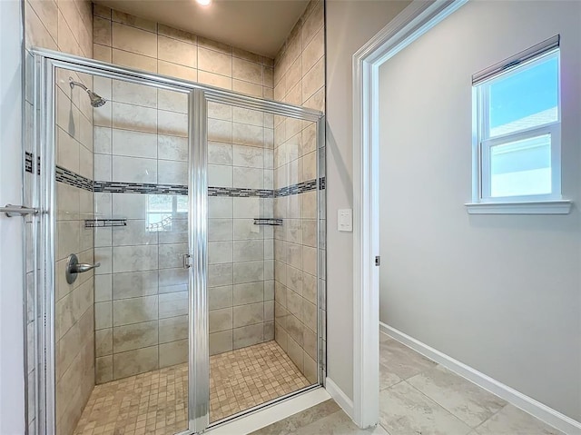 full bath with a stall shower and baseboards