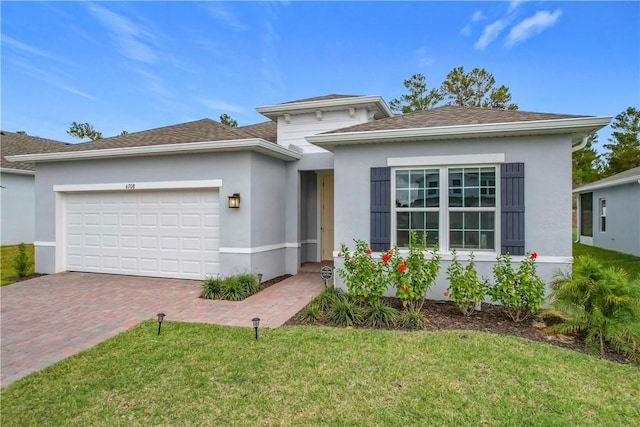 view of front of home with an attached garage, a shingled roof, decorative driveway, stucco siding, and a front yard