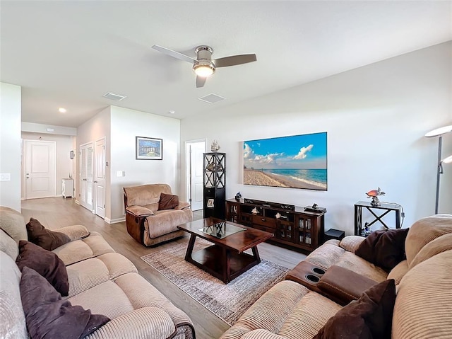 living area with visible vents, ceiling fan, and wood finished floors