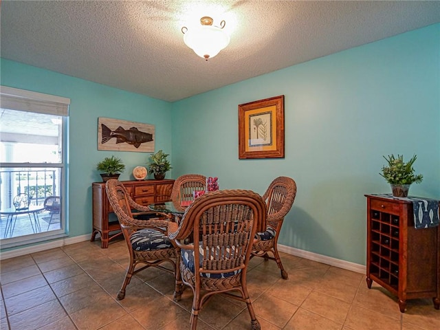 tiled dining area featuring a textured ceiling