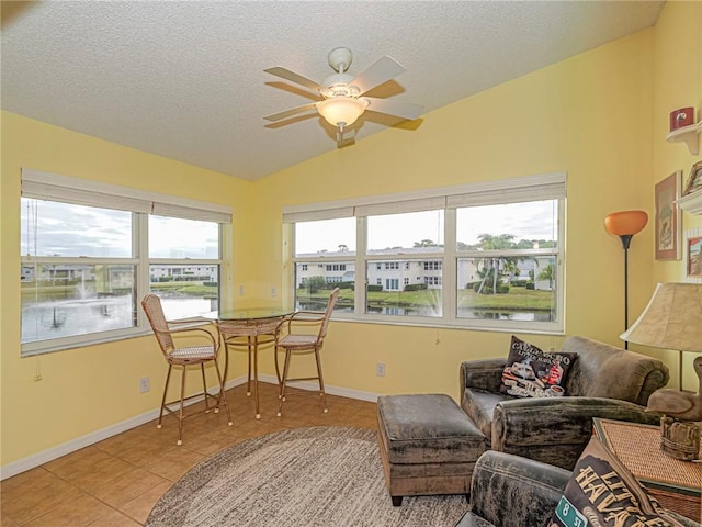 sunroom with vaulted ceiling, a water view, and ceiling fan