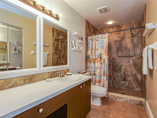 bathroom with wooden walls, vanity, walk in shower, toilet, and tile patterned floors