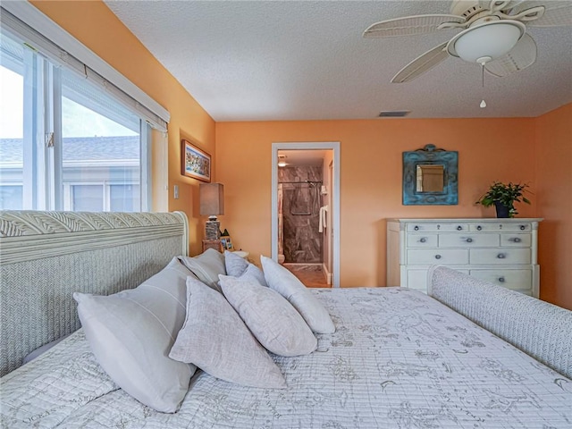 bedroom with ensuite bathroom, a textured ceiling, and ceiling fan