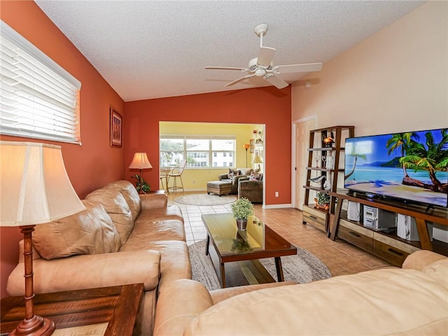 tiled living room with ceiling fan, lofted ceiling, and a textured ceiling