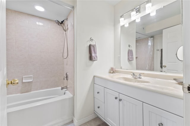 bathroom with tiled shower / bath and vanity