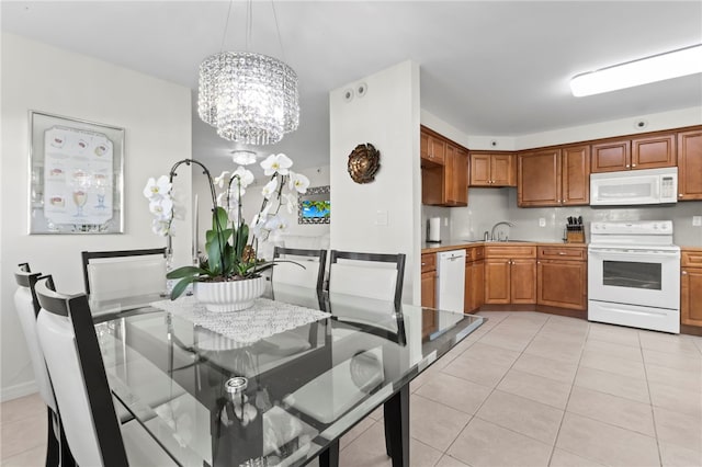 dining area with an inviting chandelier, sink, and light tile patterned flooring