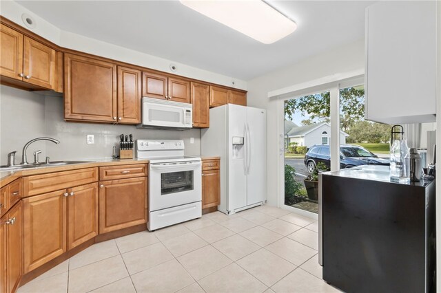 kitchen featuring sink, light tile patterned floors, and white appliances