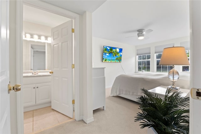 carpeted bedroom with ceiling fan, sink, and ensuite bath