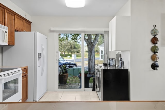 kitchen featuring light tile patterned flooring and white appliances