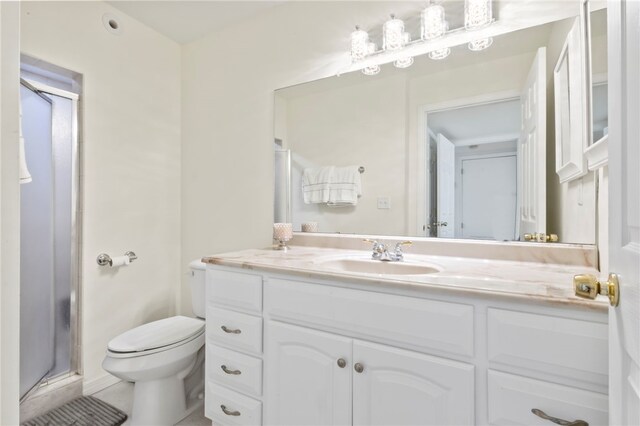 bathroom with vanity, walk in shower, and toilet