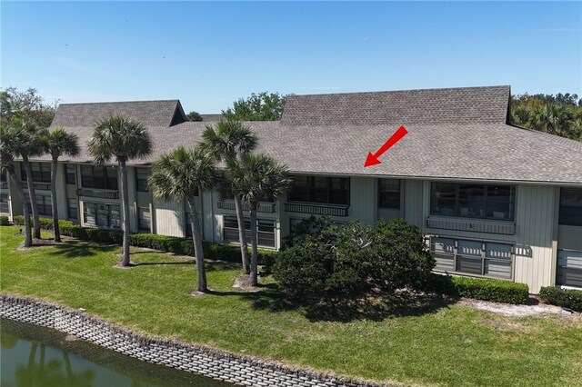 view of front facade featuring a water view and a front lawn