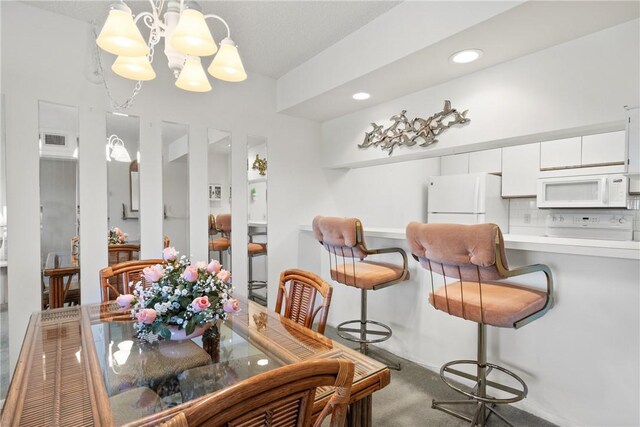 dining space featuring carpet floors, a notable chandelier, recessed lighting, and visible vents