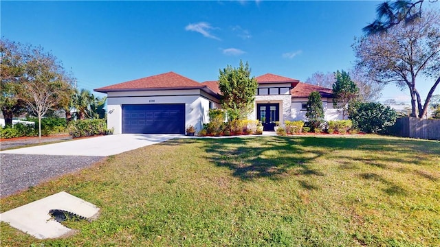 mediterranean / spanish-style home with a front lawn, a garage, and french doors