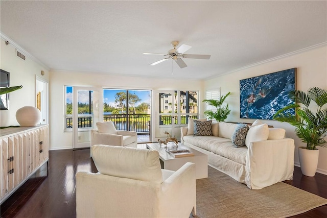 living area featuring baseboards, visible vents, a ceiling fan, ornamental molding, and dark wood-type flooring