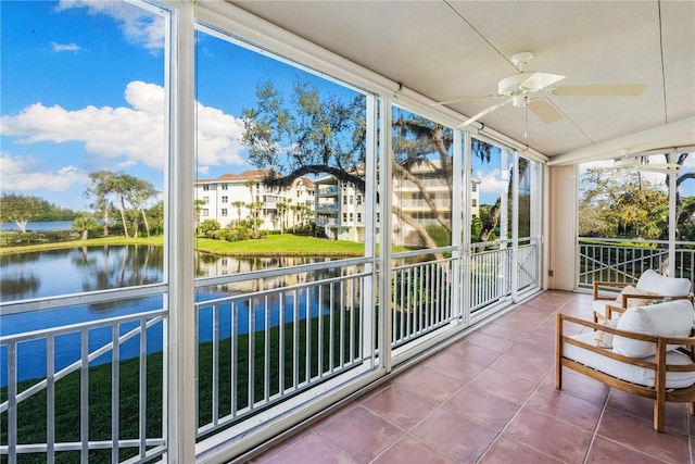 sunroom with a water view and ceiling fan