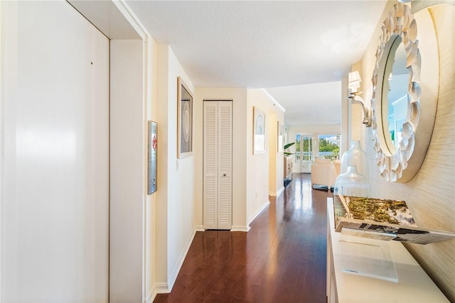 hallway with baseboards, dark wood-style flooring, and elevator