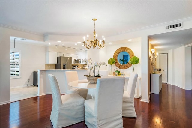 dining room featuring dark wood-style floors, crown molding, visible vents, an inviting chandelier, and baseboards