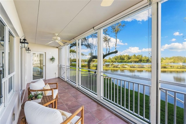 sunroom featuring a water view and ceiling fan