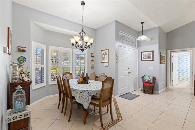 tiled dining area featuring an inviting chandelier, a textured ceiling, and vaulted ceiling