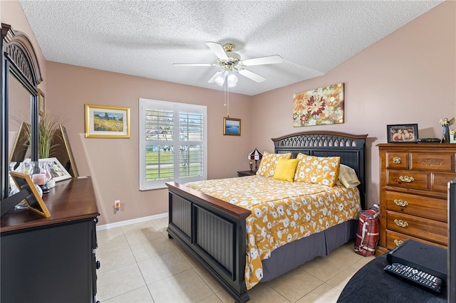 bedroom featuring a textured ceiling, light tile patterned floors, and ceiling fan