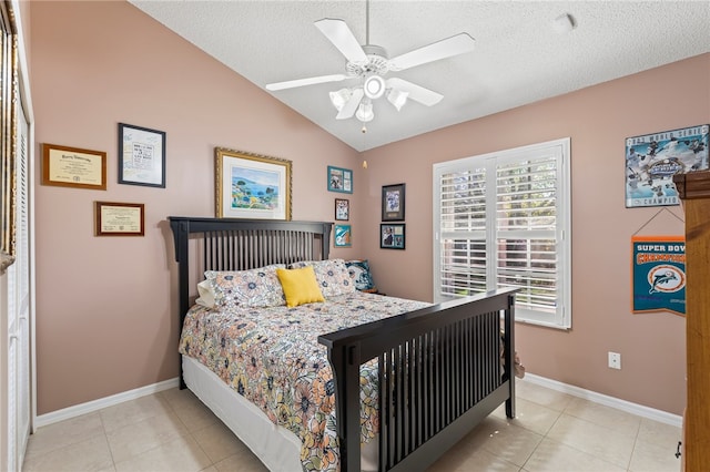 tiled bedroom featuring a textured ceiling, ceiling fan, and vaulted ceiling