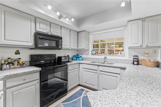 kitchen featuring black appliances, light tile patterned floors, a raised ceiling, light stone countertops, and sink