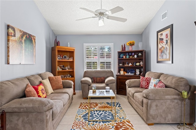 living room featuring ceiling fan, lofted ceiling, a textured ceiling, and light tile patterned flooring