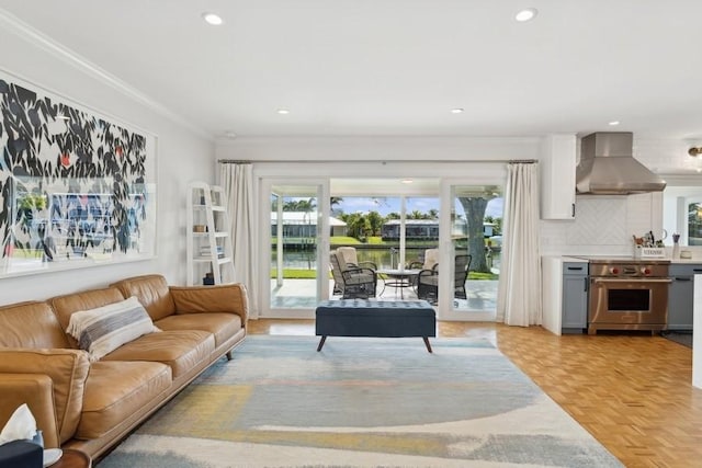 living room with light parquet flooring, plenty of natural light, and ornamental molding