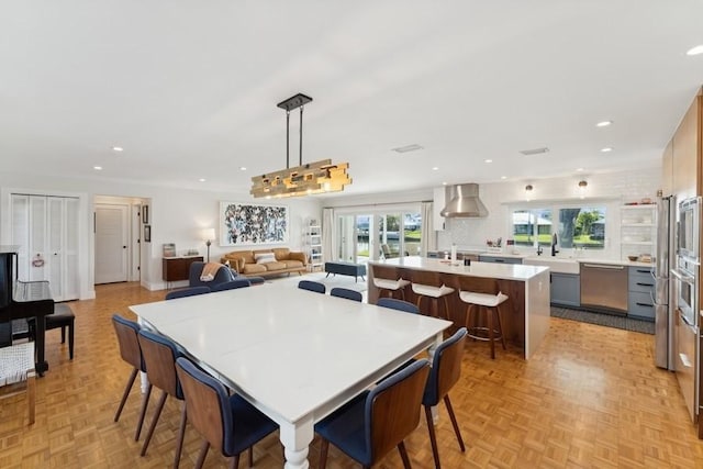 dining space with a healthy amount of sunlight, light parquet flooring, and sink