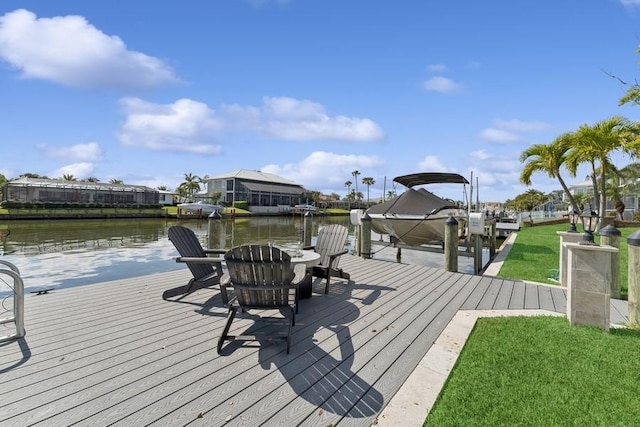 view of dock with a water view and a lawn