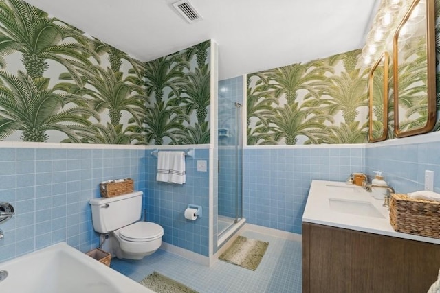 full bathroom featuring toilet, shower with separate bathtub, tile walls, vanity, and tile patterned flooring